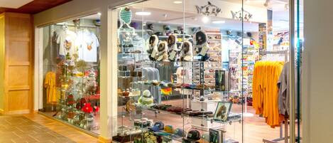 A store with glass display windows showcasing various hats and clothing items.