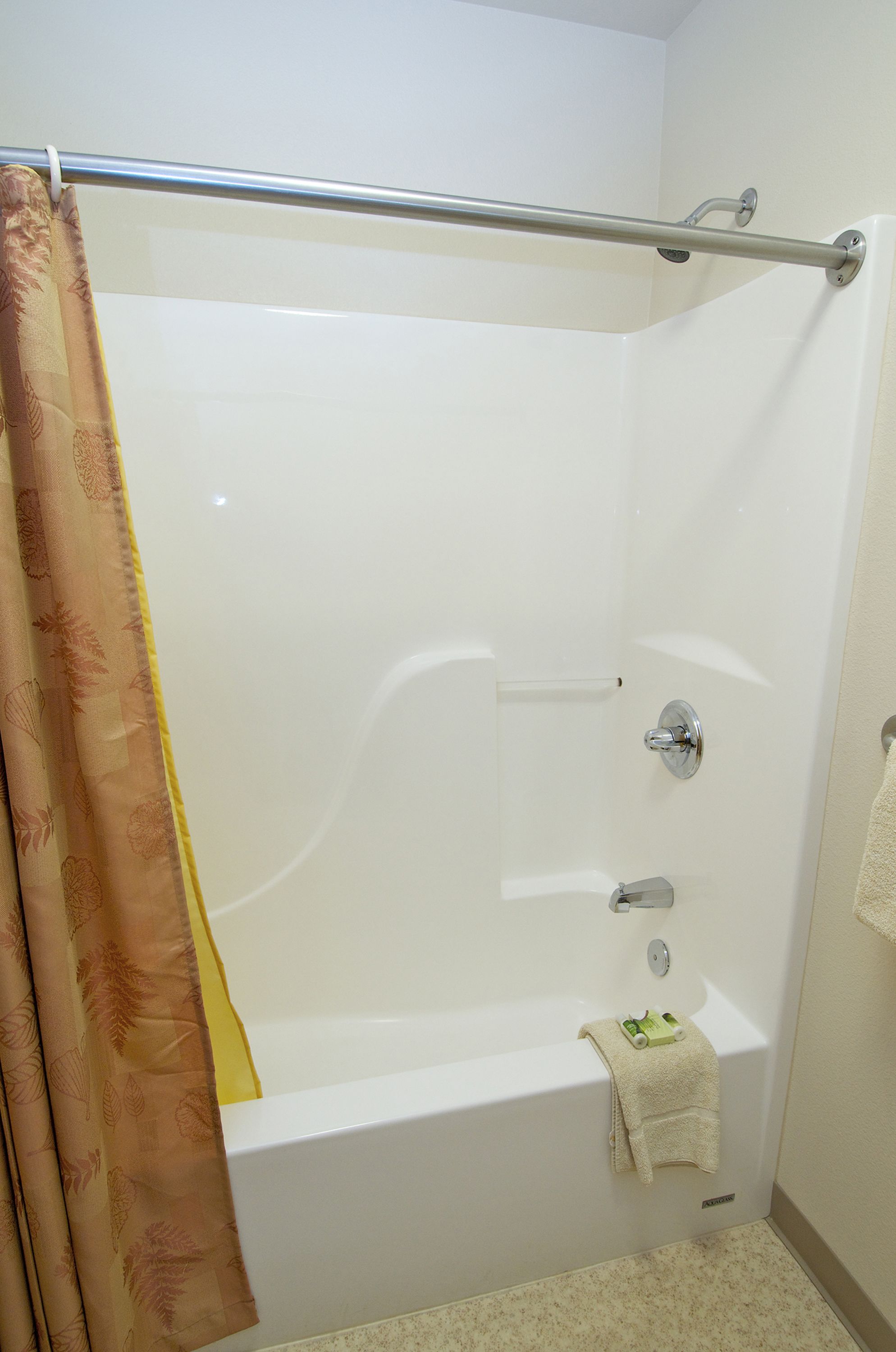 A bathroom with a bathtub, a shower curtain, and a towel rack.
