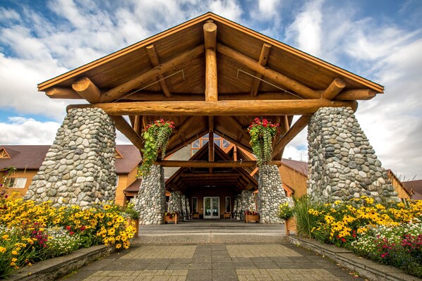 A lodge with a stone facade, wooden beams, and a covered entrance.