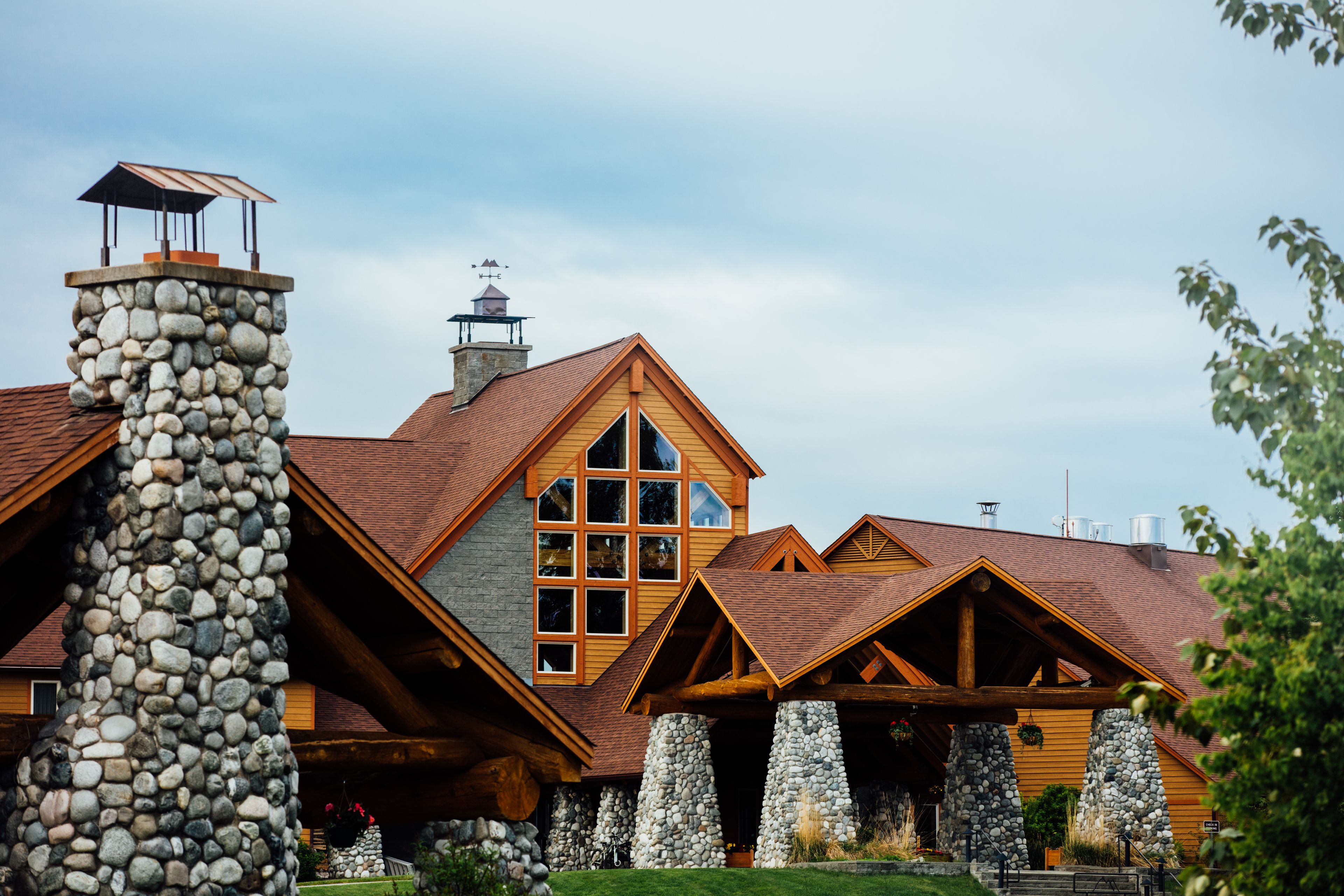 A stone chimney, a large wooden window, and a stone pillar.