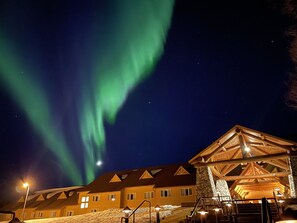 A building with a sloped roof and multiple windows, surrounded by snow. - Talkeetna Alaskan Lodge (Talkeetna)
