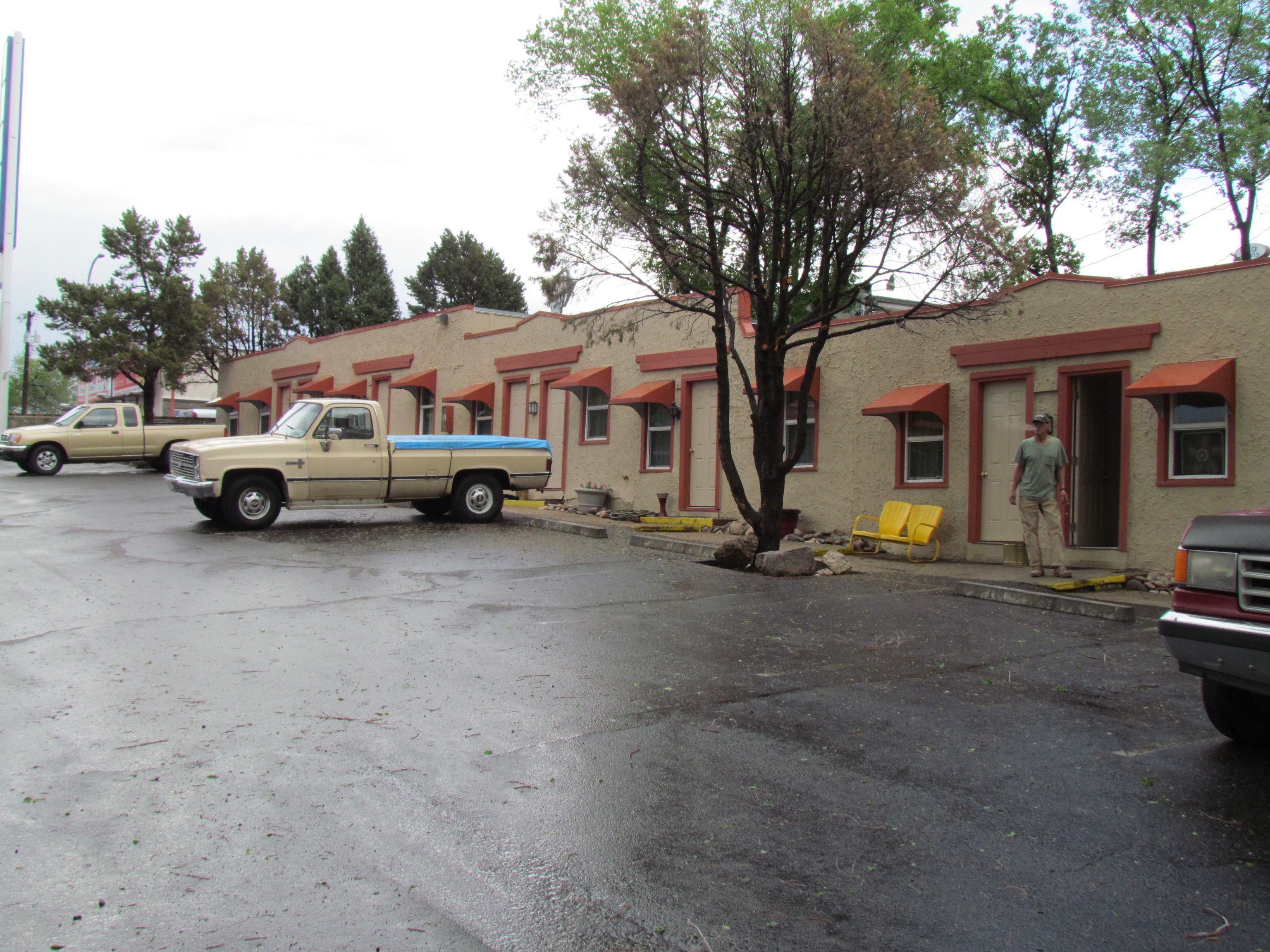 Une rangée de bâtiments d’un motel, avec un parking devant.