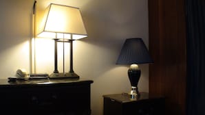 A desk with two lamps, one with a white shade and another with a dark shade, and a telephone on the left side. - Schuyler Inn (Schuyler)