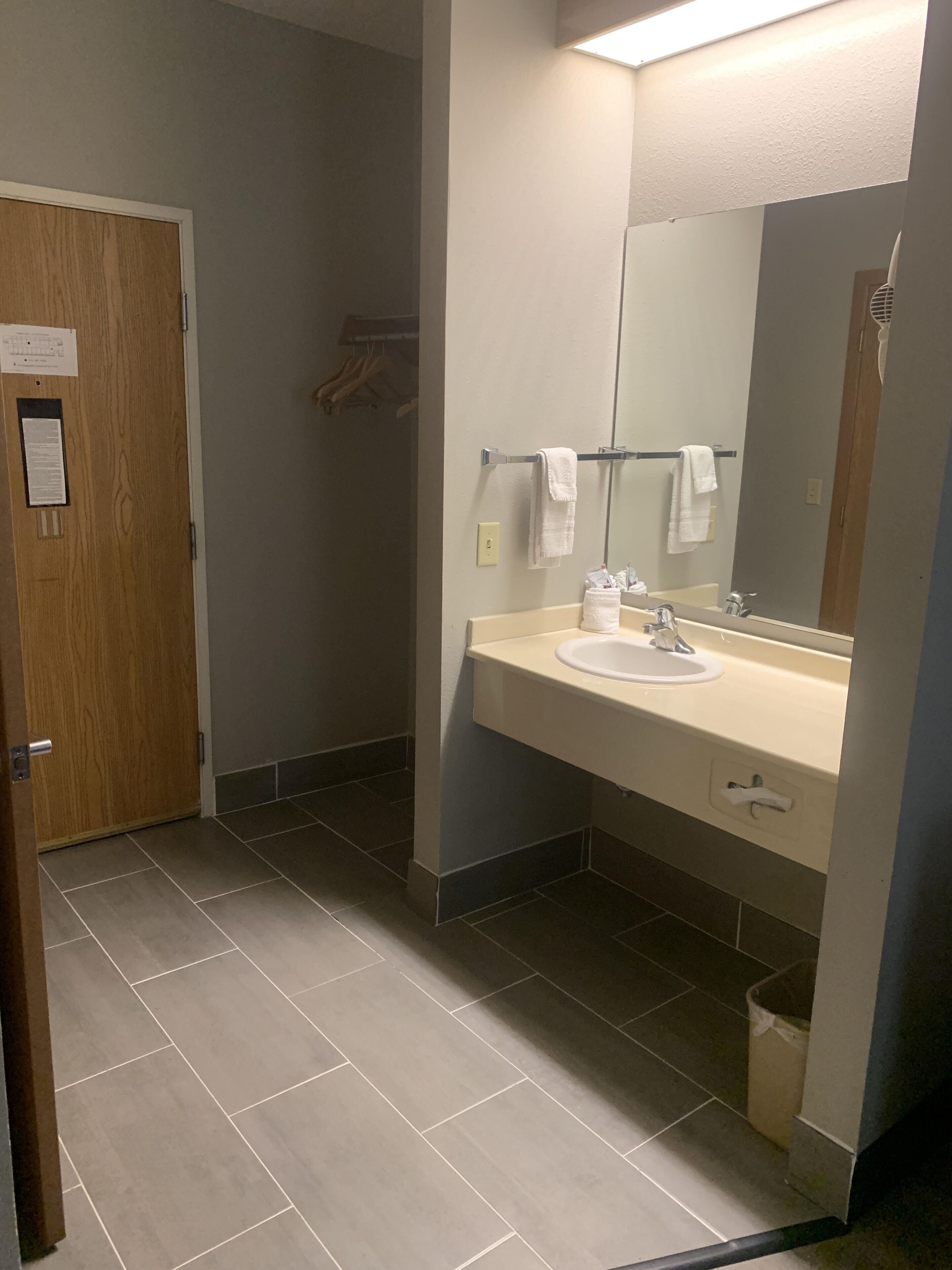 Un bagno con lavandino, specchio e porta asciugamani.