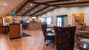 A spacious lobby with a reception desk, seating area, and large windows. - Van Hook Territorial Inn (New Town)