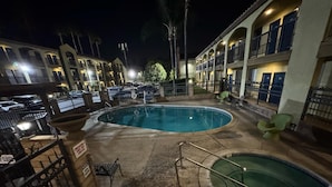 A pool area with two pools, a covered seating area, and a building with multiple balconies. - Five Star Inn West Covina (West Covina)