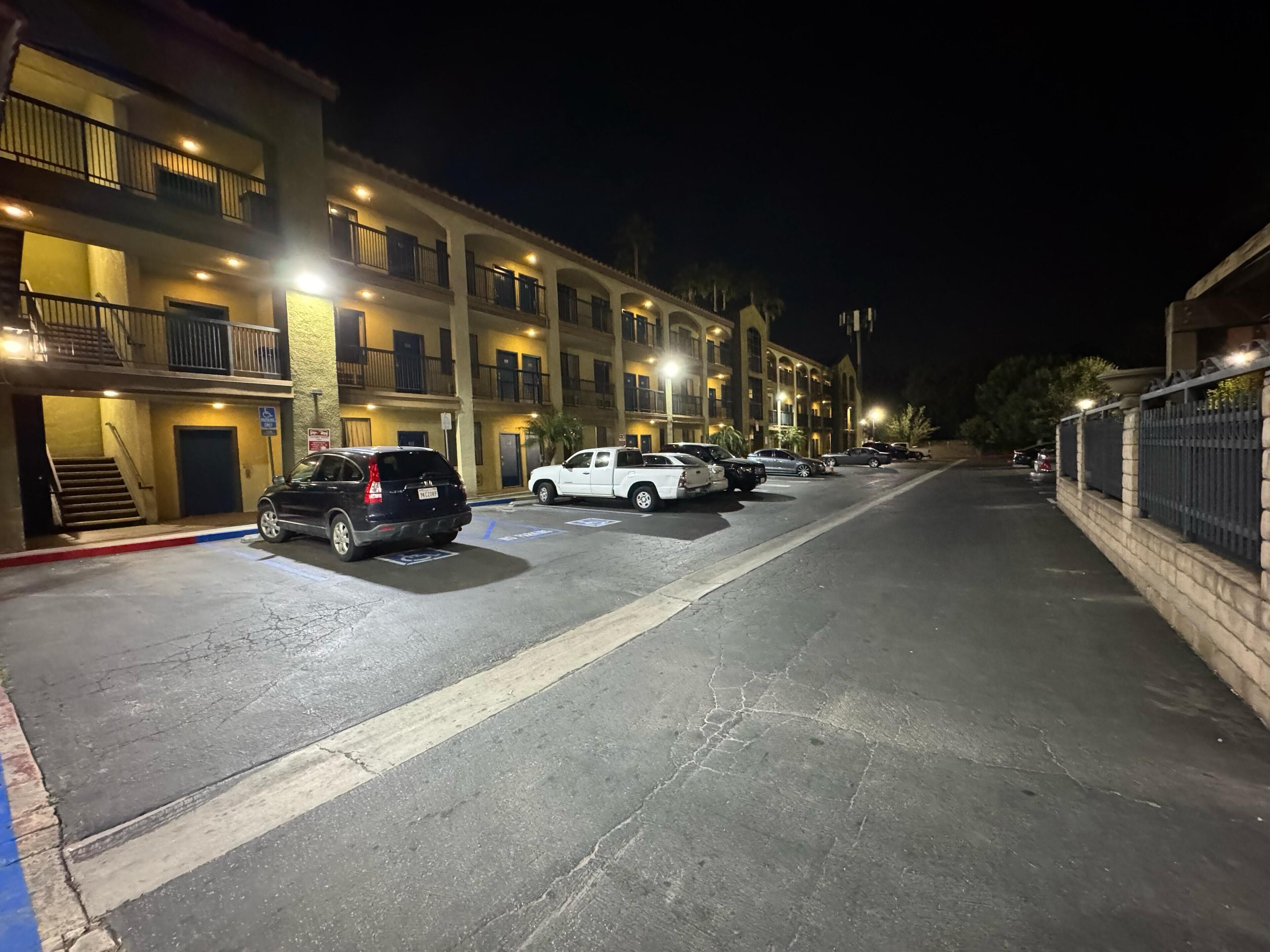 Un garaje de varios pisos con varios automóviles estacionados, iluminado por luces superiores.