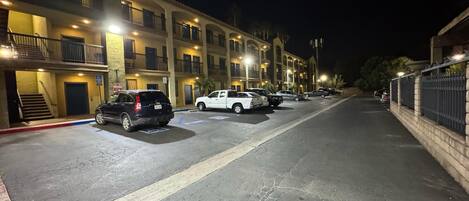 Un garaje de varios pisos con varios automóviles estacionados, iluminado por luces superiores.