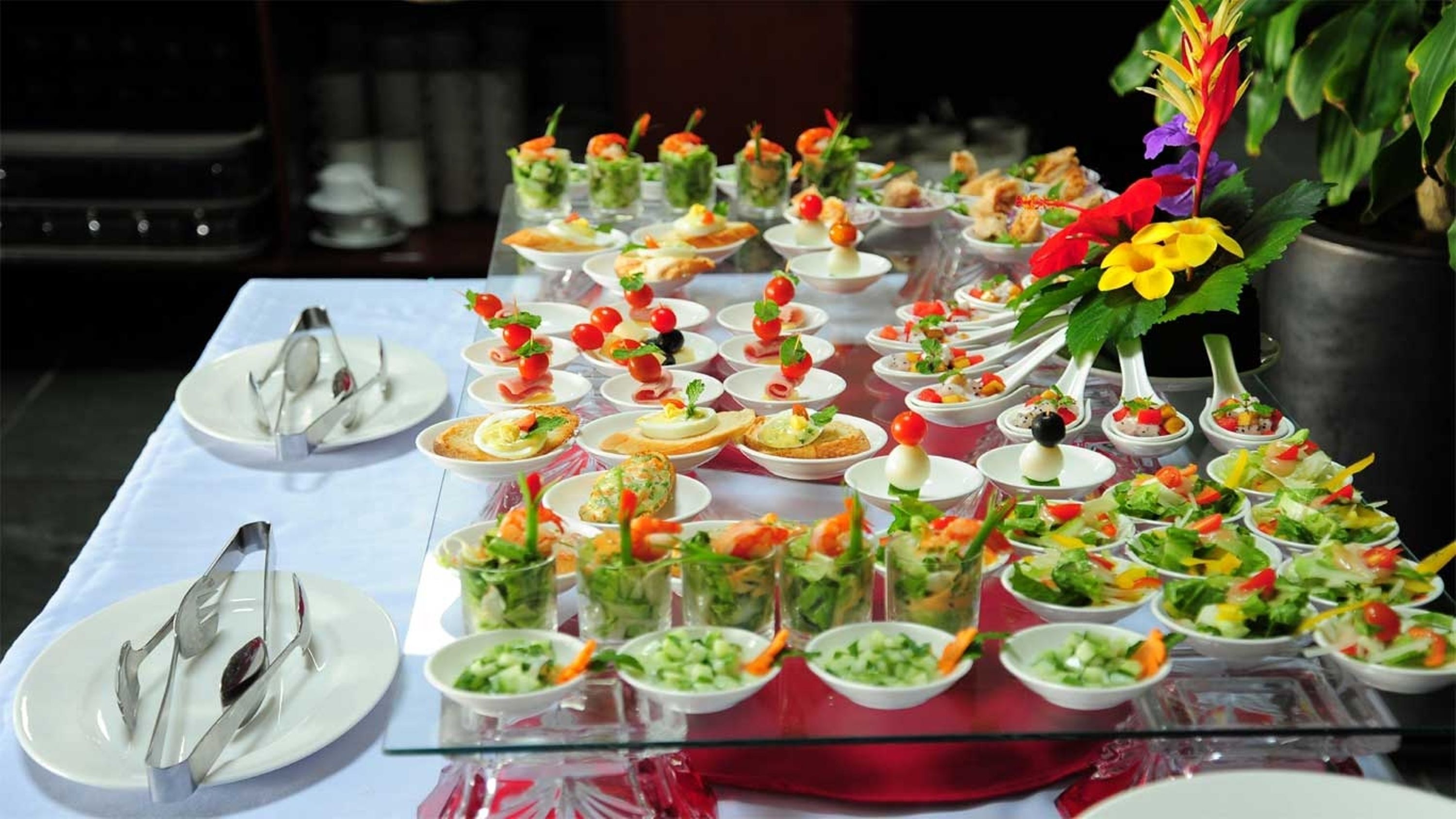 A buffet table with various dishes and utensils.