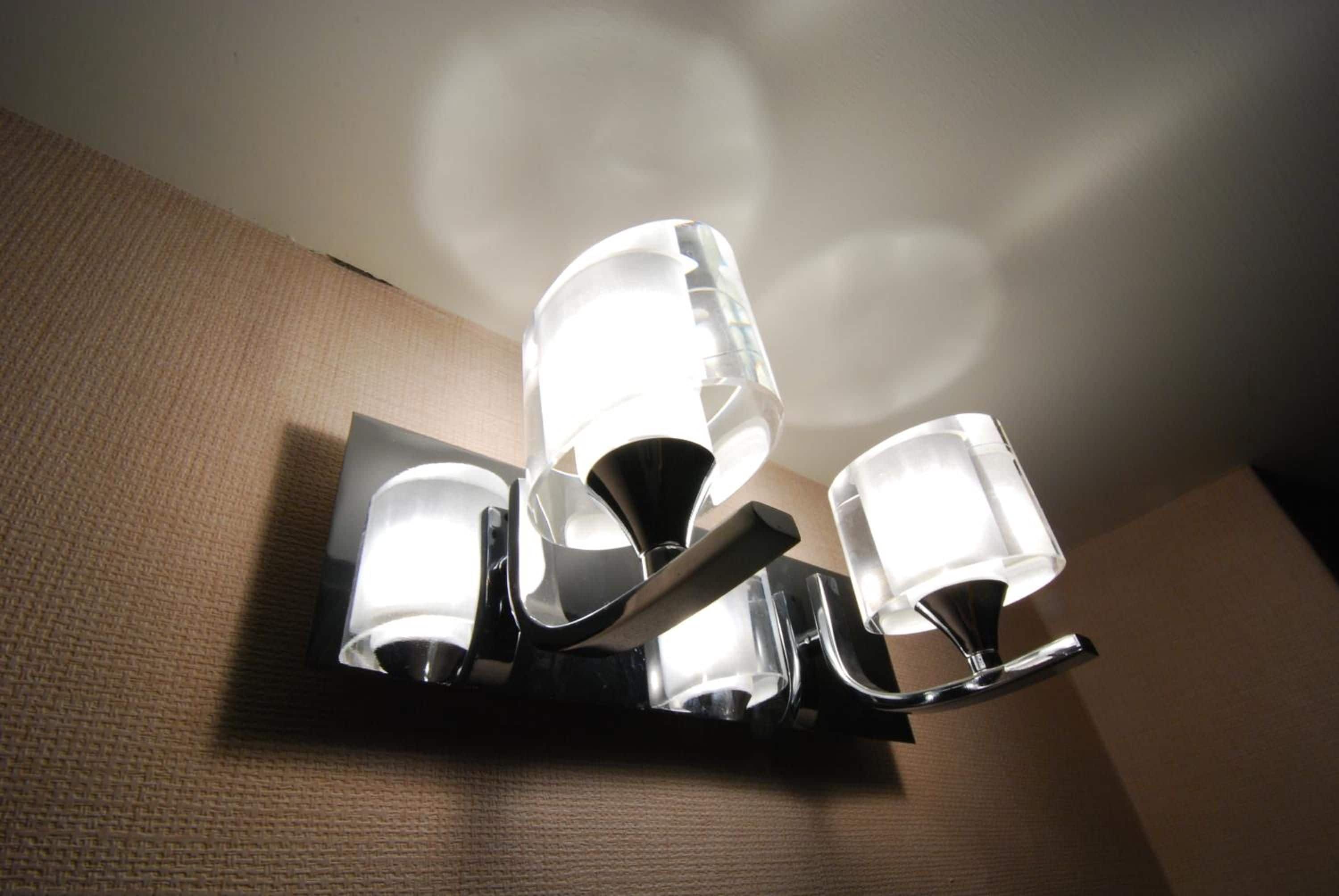 A wall-mounted light fixture with three glass shades.
