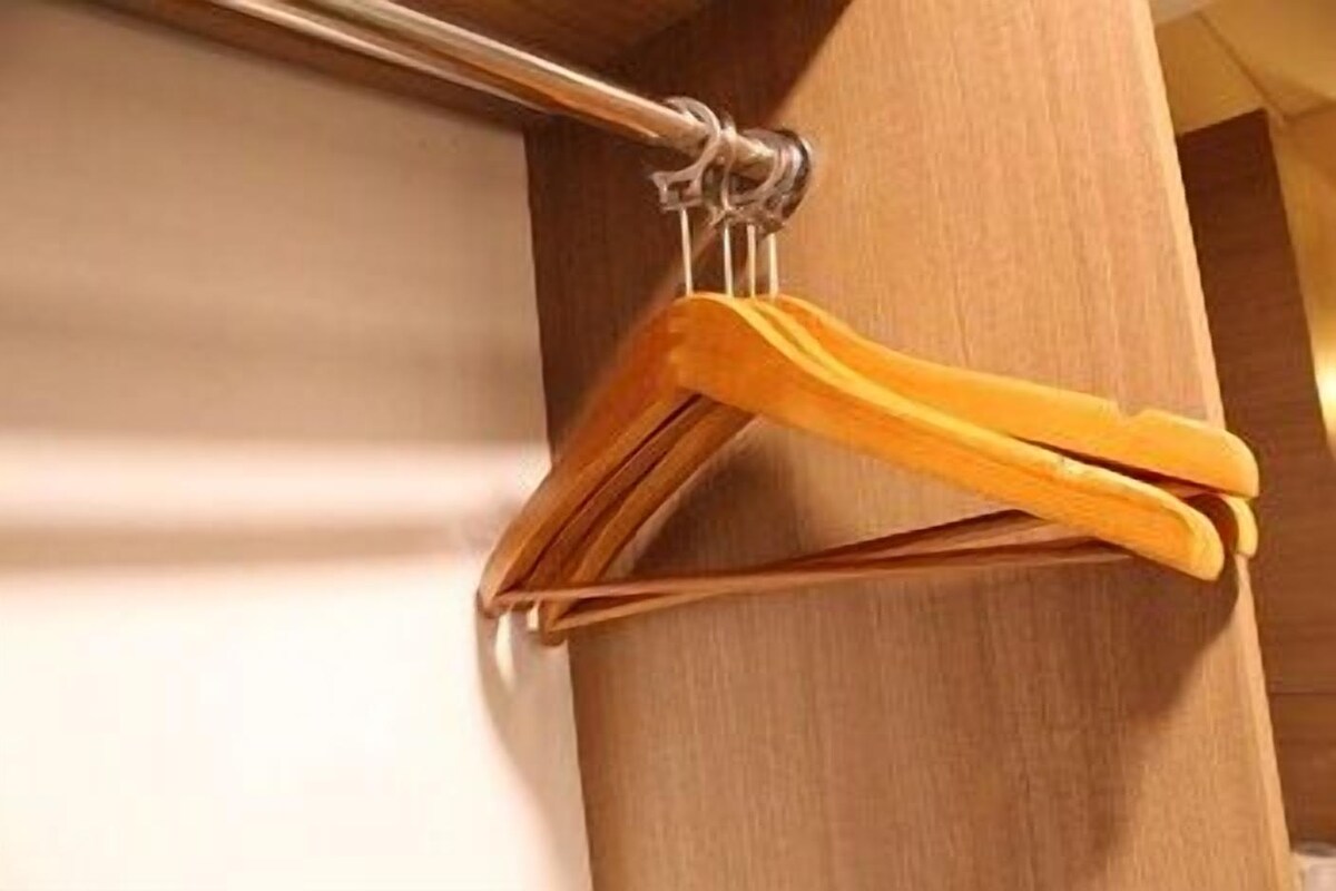 A wooden hanger rack with yellow hangers.