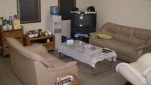Un soggiorno con un divano, un tavolino e una televisione.