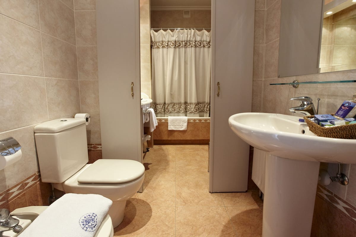 Ein Badezimmer mit Toilette, Waschbecken und Duschvorhang.