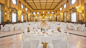 A large banquet hall with round tables set for dining, chandeliers, and large mirrors on the walls. - Gran Hotel Balneario de Cestona (Zestoa)