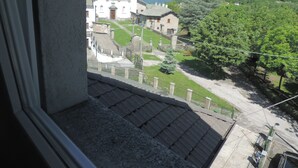 Een uitzicht op een kerk met een klokkentoren, omringd door weelderige groene heuvels en een heldere lucht.