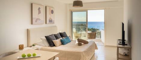 A modern bedroom with a large bed, a dining table, and a TV.