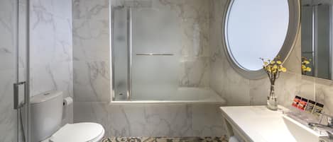 Een moderne badkamer met toilet, douche en bad.