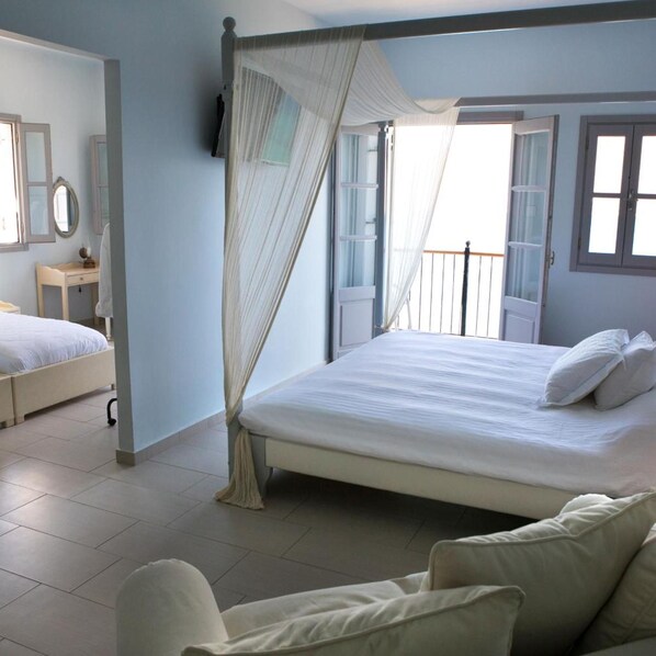 Un dormitorio con cama, mesita de noche, espejo y ventana con cortinas.
