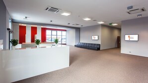 A spacious reception area with a counter, seating, and a large window.