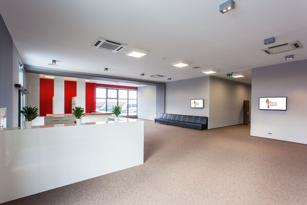 A spacious reception area with a counter, seating, and a large window.