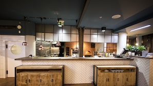 Une cuisine moderne avec des meubles en bois, un dosseret orné d’un motif en chevrons et des luminaires suspendus.