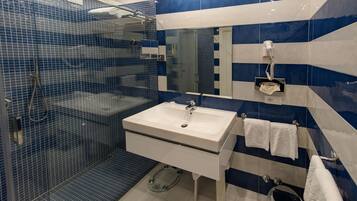 A bathroom with a glass shower enclosure, a sink, and a toilet.