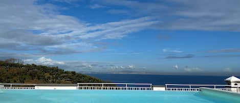 Una piscina al aire libre de temporada, sombrillas