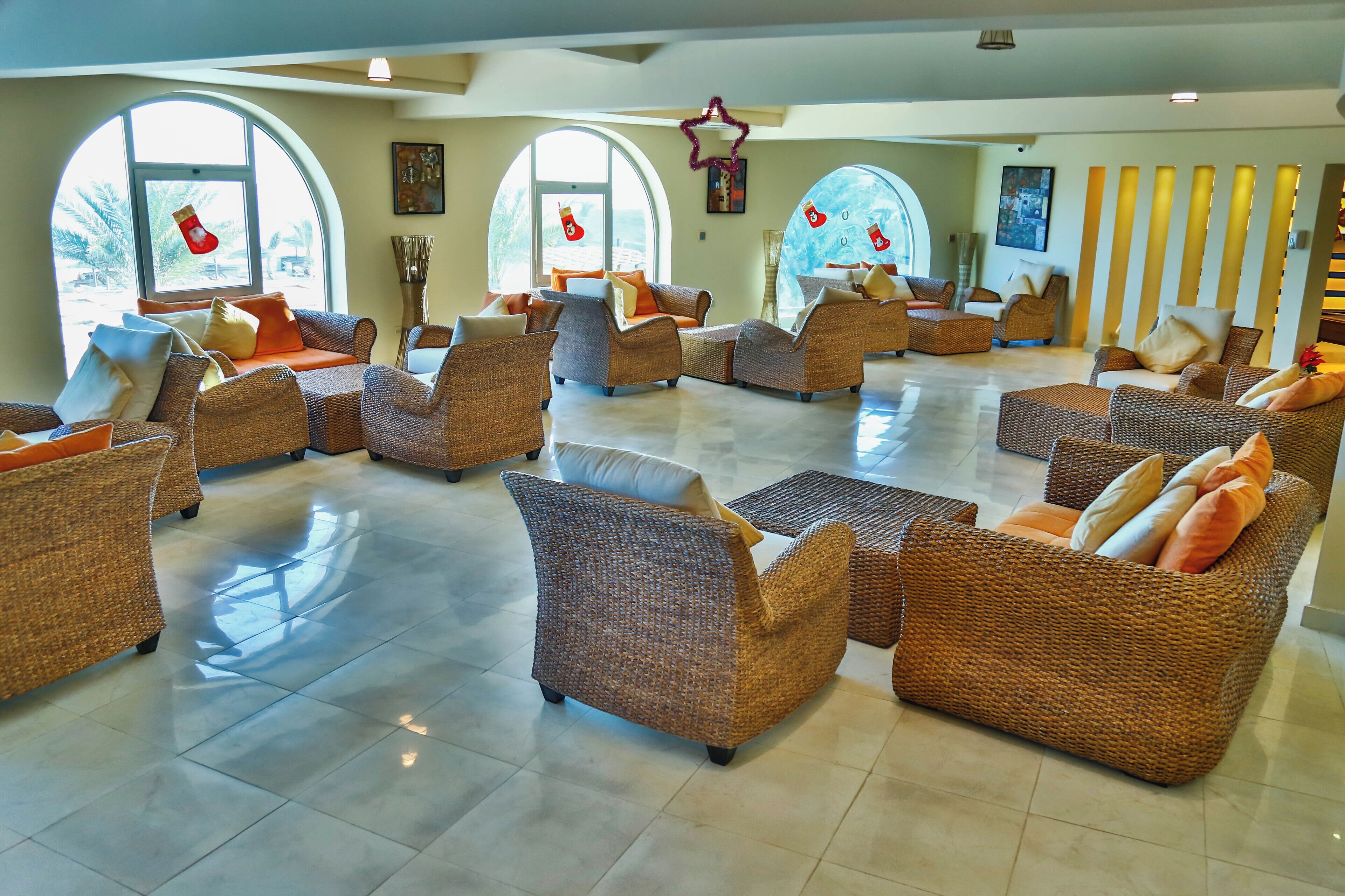 A spacious lobby with wicker furniture, large windows, and Christmas stockings.