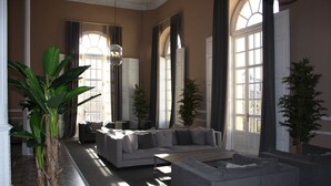 A spacious living room with a large sofa, a coffee table, and several potted plants. - Hotel Termas - Balneario Termas Pallarés (Alhama de Aragon)