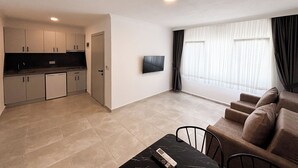 A modern apartment with a kitchen, dining area, and living room. - Green House Apart Hotel (Bodrum)