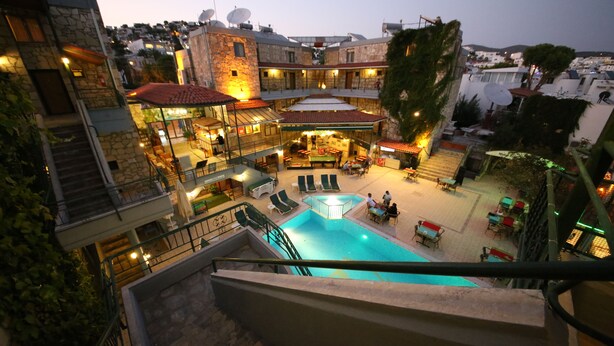 A multi-level hotel with a swimming pool, outdoor seating, and a view of the surrounding area. - Green House Apart Hotel (Bodrum)
