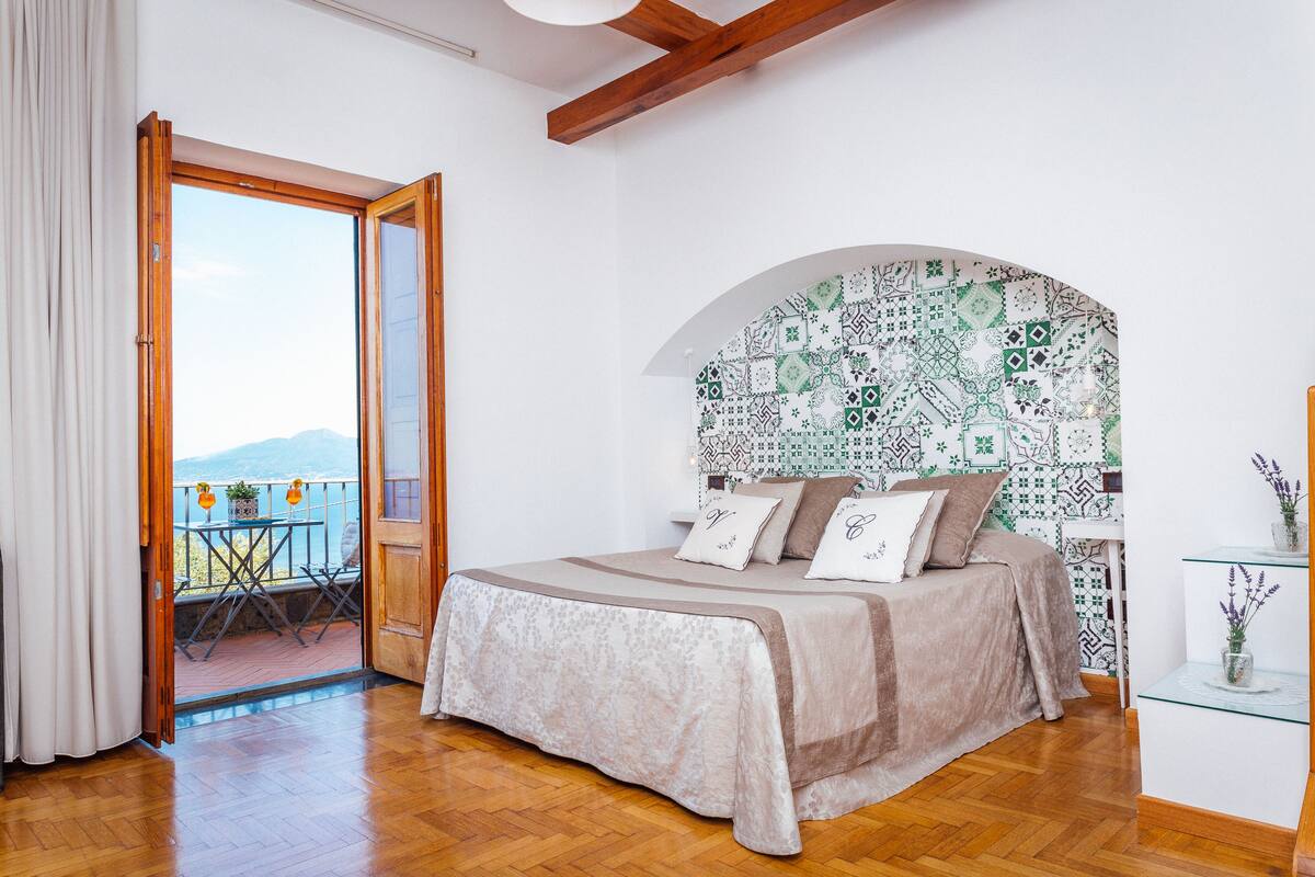 Une chambre à coucher avec un lit, un balcon et un mur décoré de motifs.