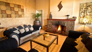 A cozy living room with a fireplace, a sofa set, and a coffee table. - Bahnhof Hotel Aus (Aus)