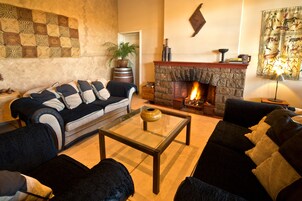Una sala de estar acogedora con chimenea, un conjunto de sofás y una mesa de centro.
