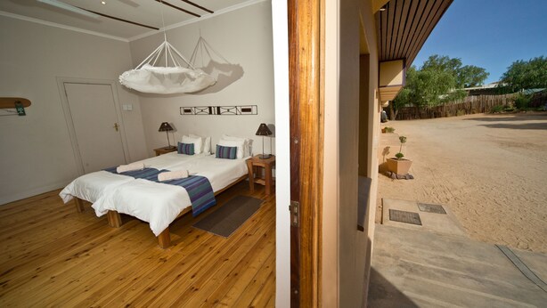 A bedroom with a large bed, bedside tables, and a hanging light fixture. - Bahnhof Hotel Aus (Aus)