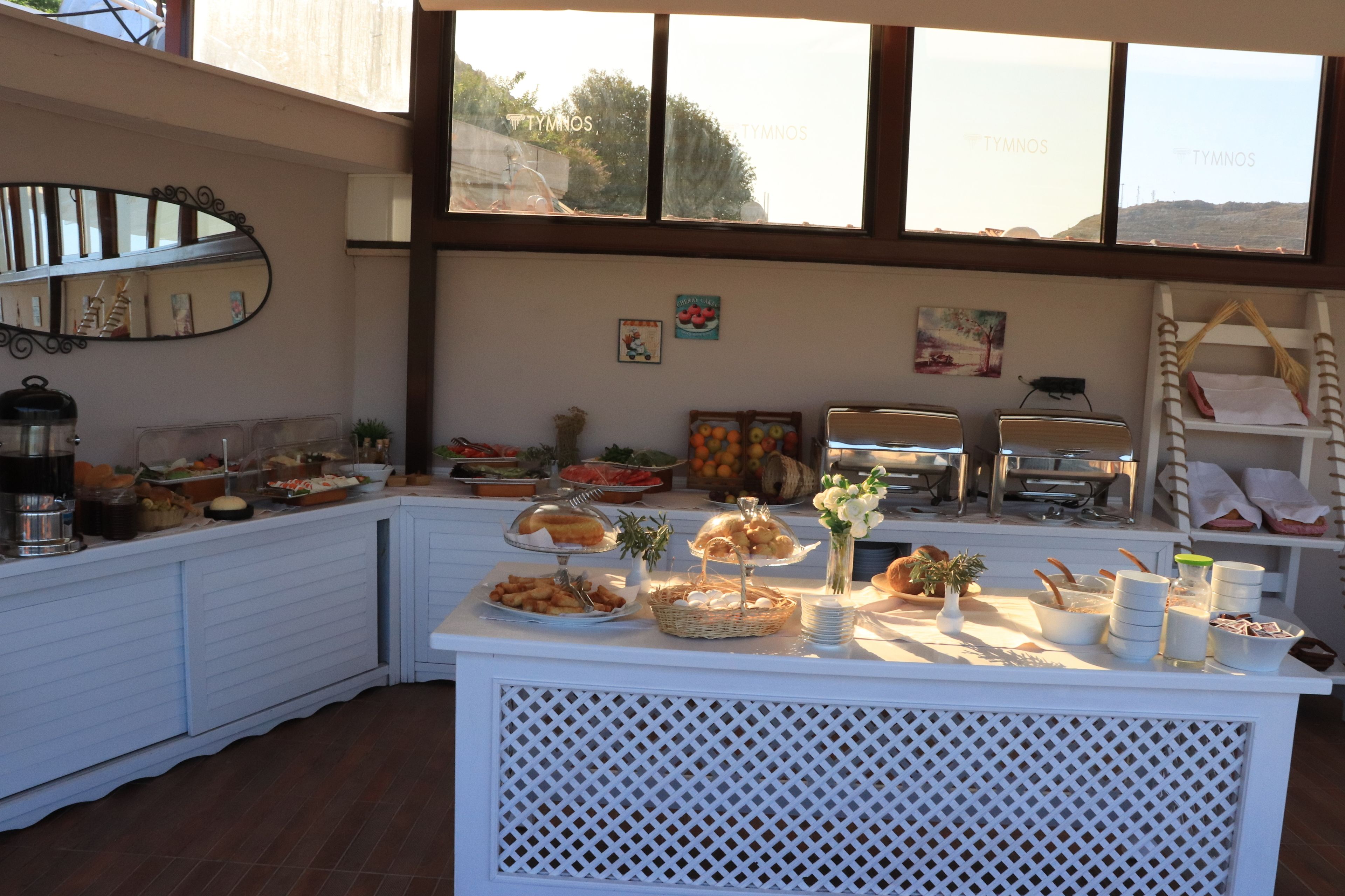 A buffet setup with various food items and a decorative mirror.