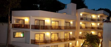 A multi-story hotel with balconies and a landscaped garden.
