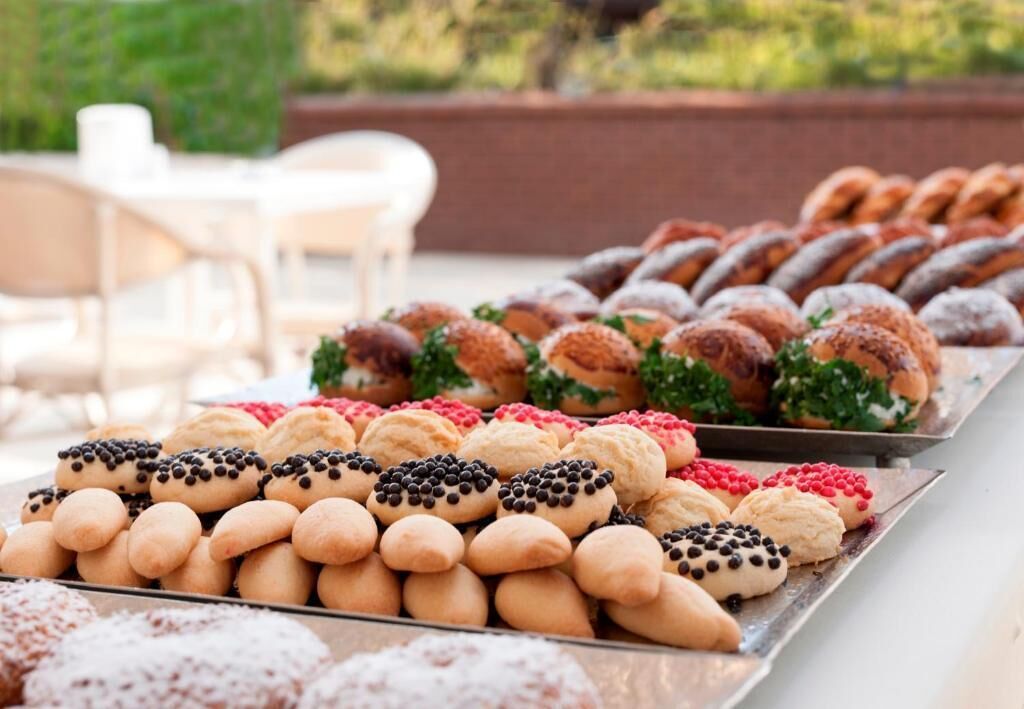 A variety of pastries displayed on trays, likely at an outdoor event or gathering.