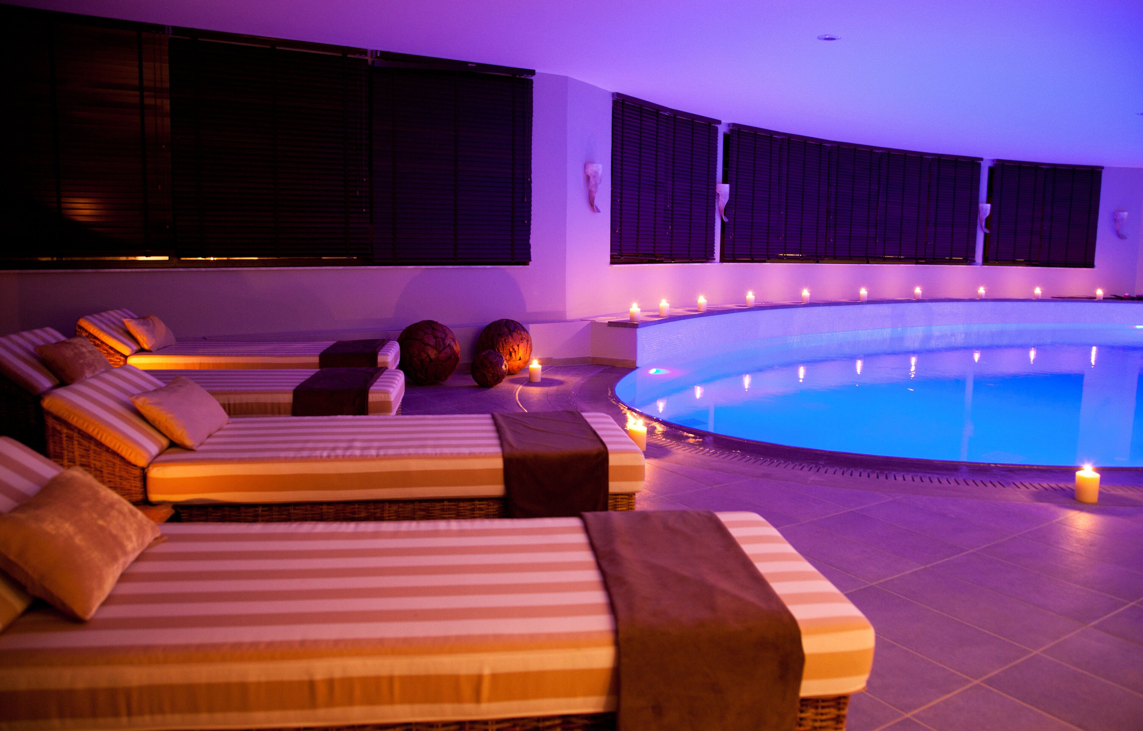 Un espace aménagé au bord de la piscine, avec plusieurs chaises longues et une piscine.
