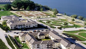 Un hotel grande con varias edificaciones, una piscina y un jardín ajardinado de diseño circular.