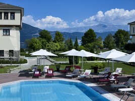 Una piscina al aire libre de temporada, sombrillas