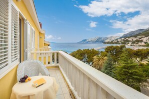 A balcony with a table, a chair, and a book. - Hotel Bacchus (Baska Voda)