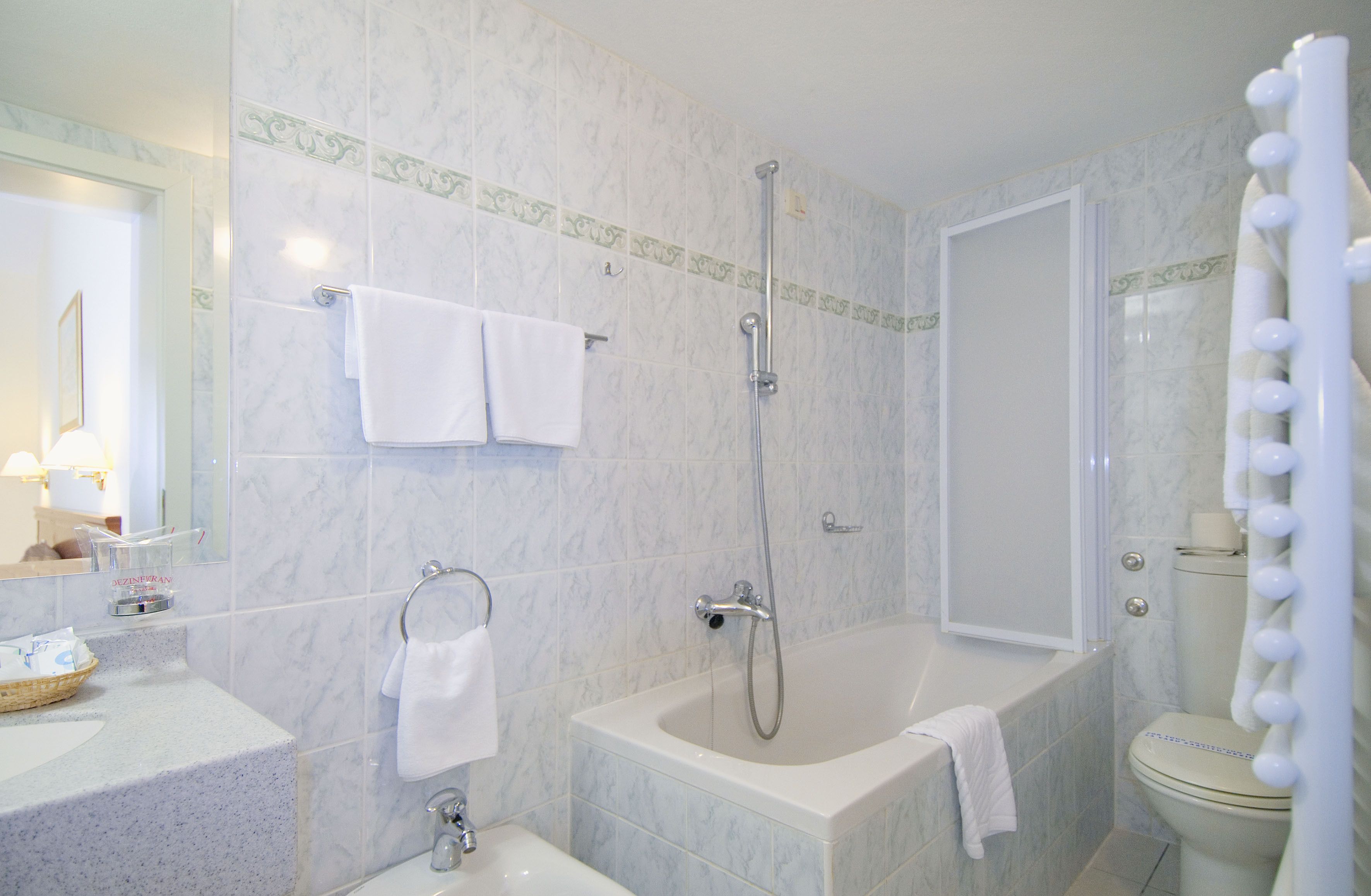 A bathroom with a bathtub, shower, toilet, and sink.