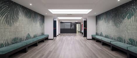 A modern lobby with a central seating area, a reception desk, and a patterned wall.