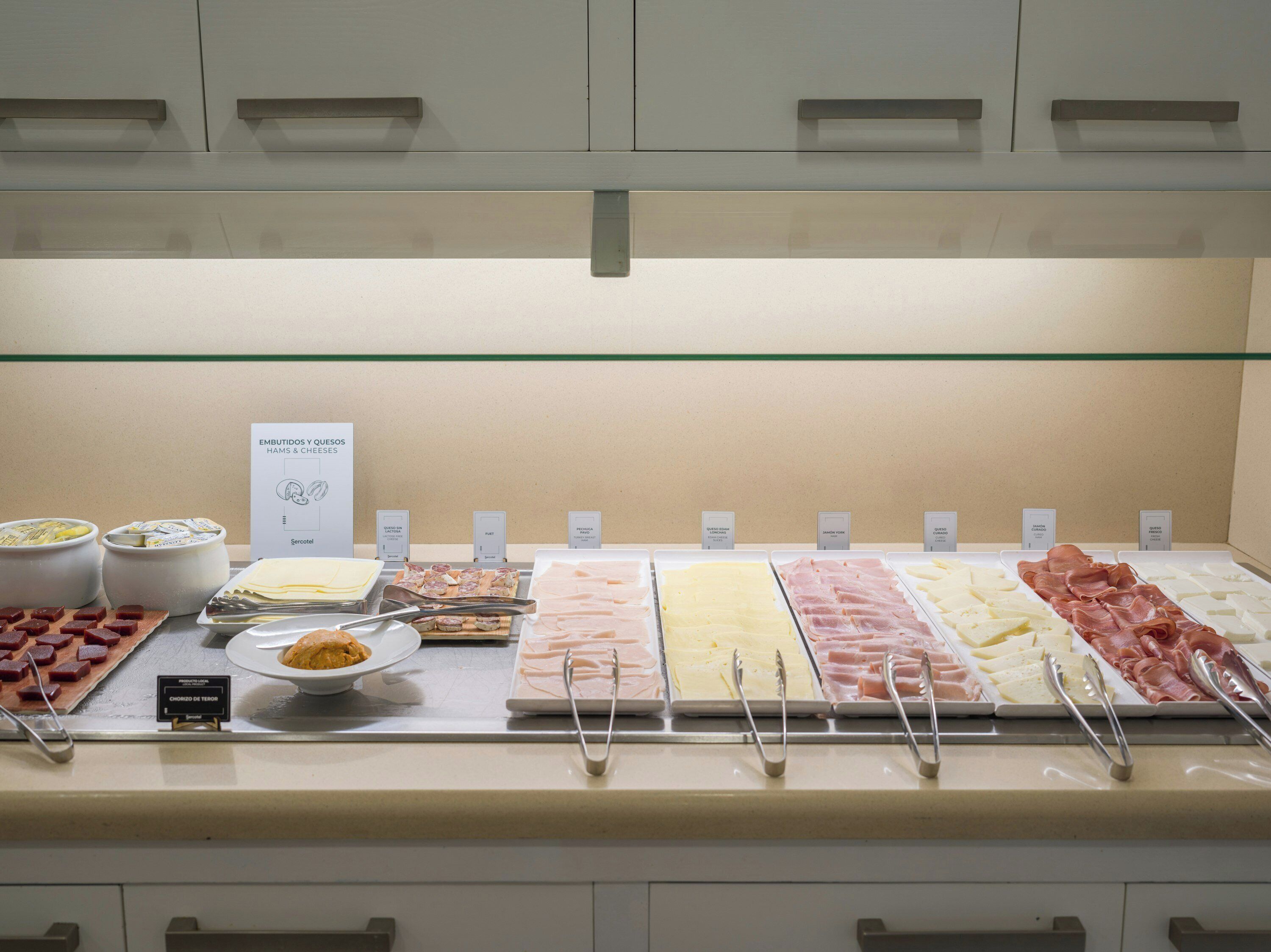 Buffet com diversos alimentos e utensílios.