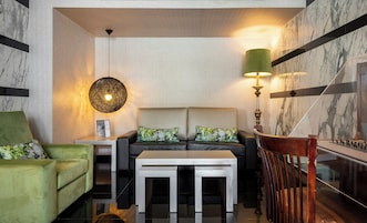 A modern living room with a sofa, armchair, and a coffee table.
