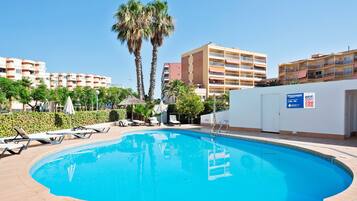 Una piscina al aire libre, tumbonas