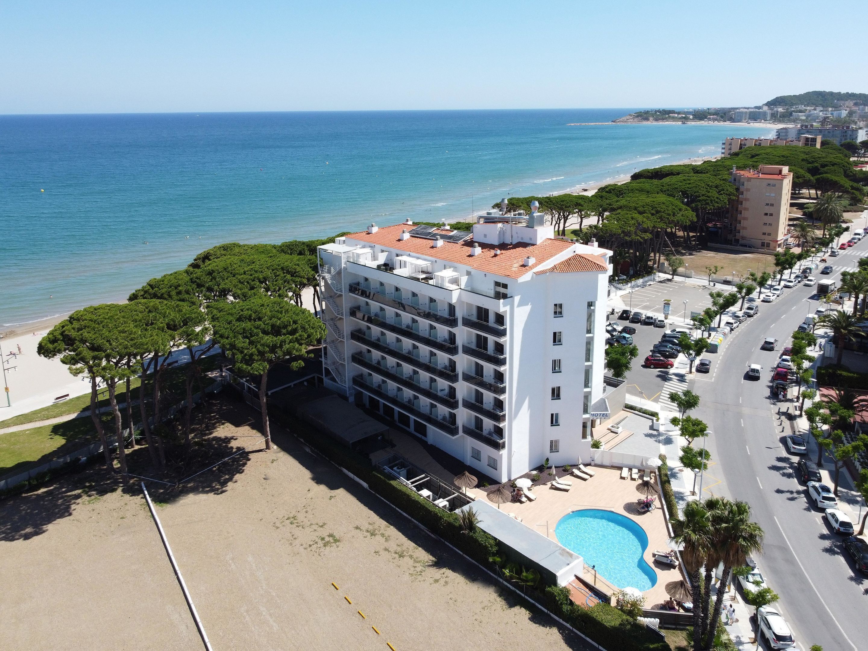 A hotel with a pool, located near a beach and ocean.