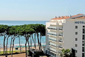 Um hotel com vários andares, varandas e vista para o mar.