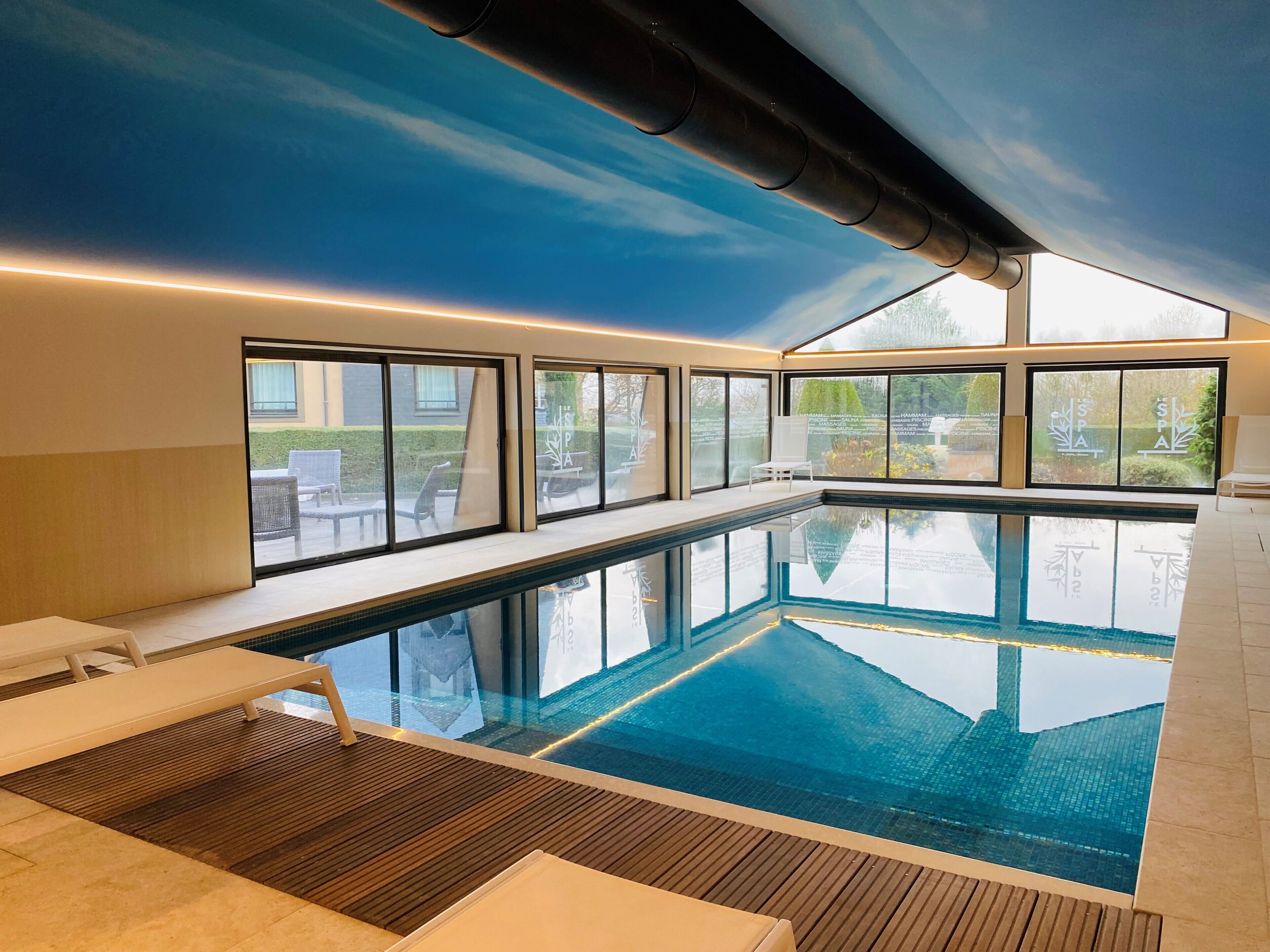 Una piscina cubierta, tumbonas